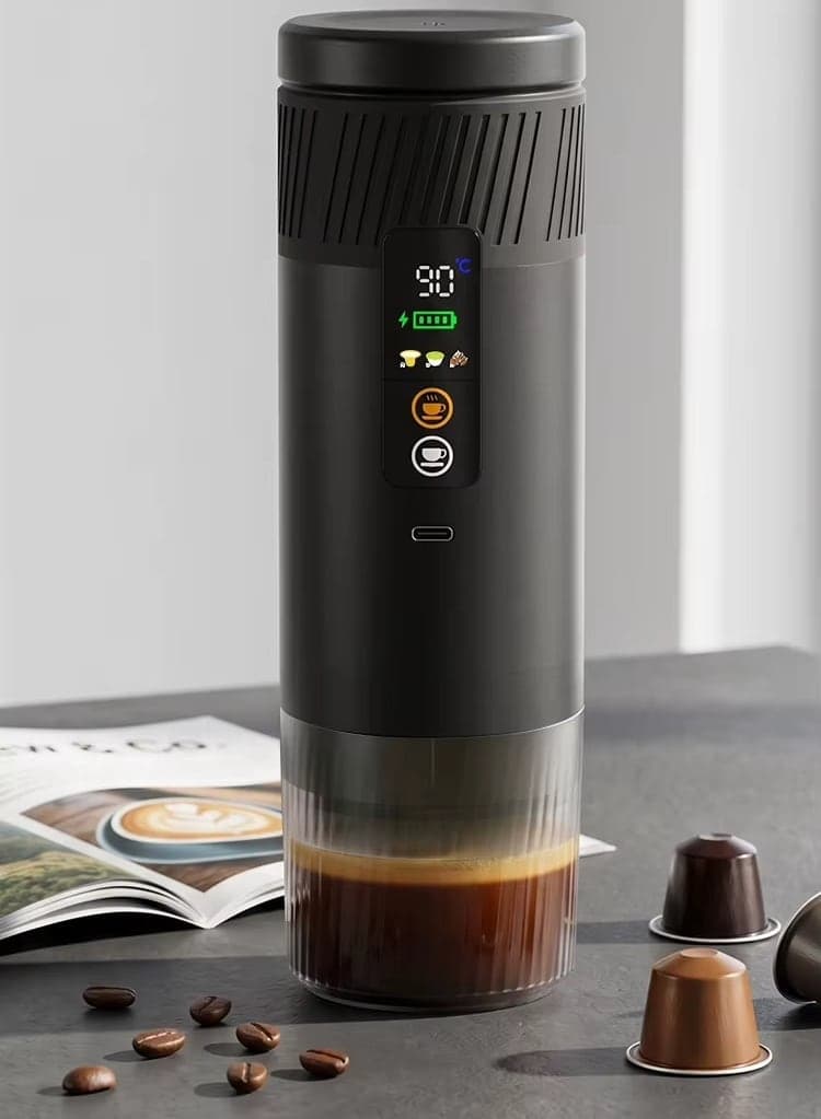 La machine à espresso portable posée sur un bureau, un espresso fraîchement extrait, deux capsules à côté